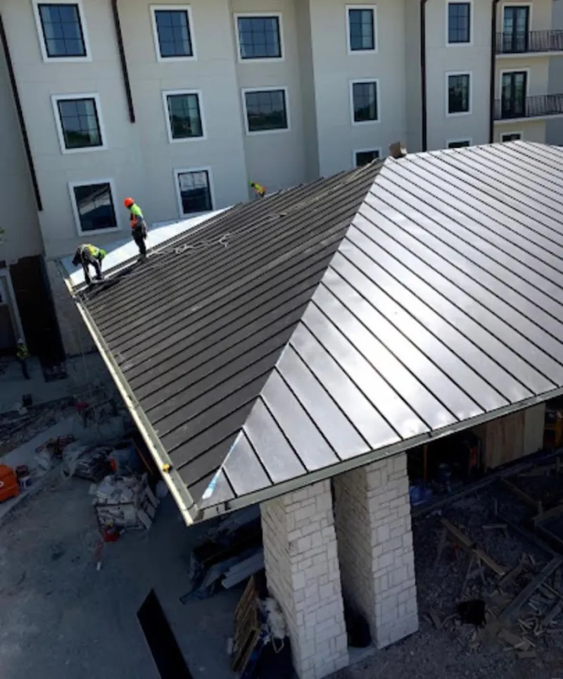 Crew installing standing seam metal roof panels on a commercial project in Lake Stevens